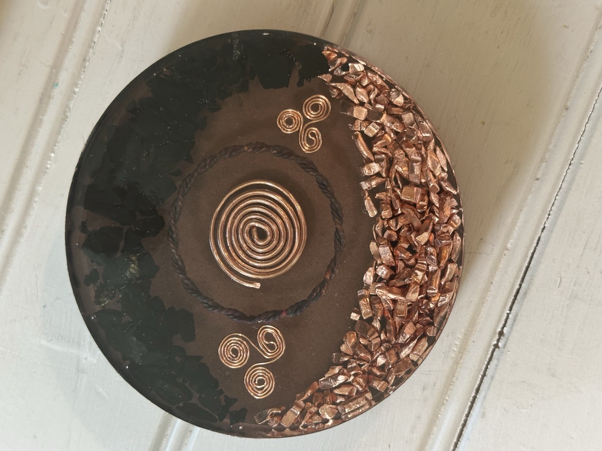 Handmade orgone coaster with center copper coil and small tensor ring set in dark resin
