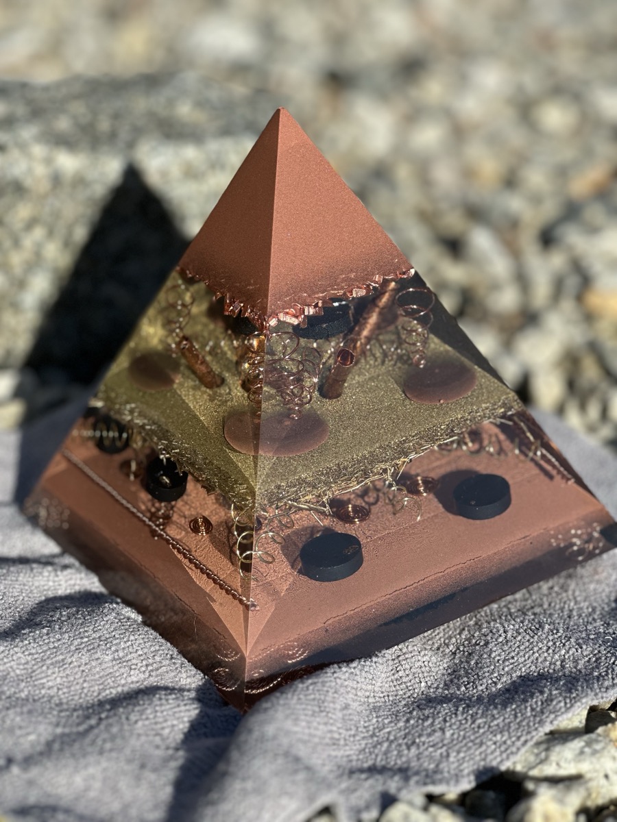 Handmade large orgonite pyramid with central copper tube surrounded by brass and shungite in resin