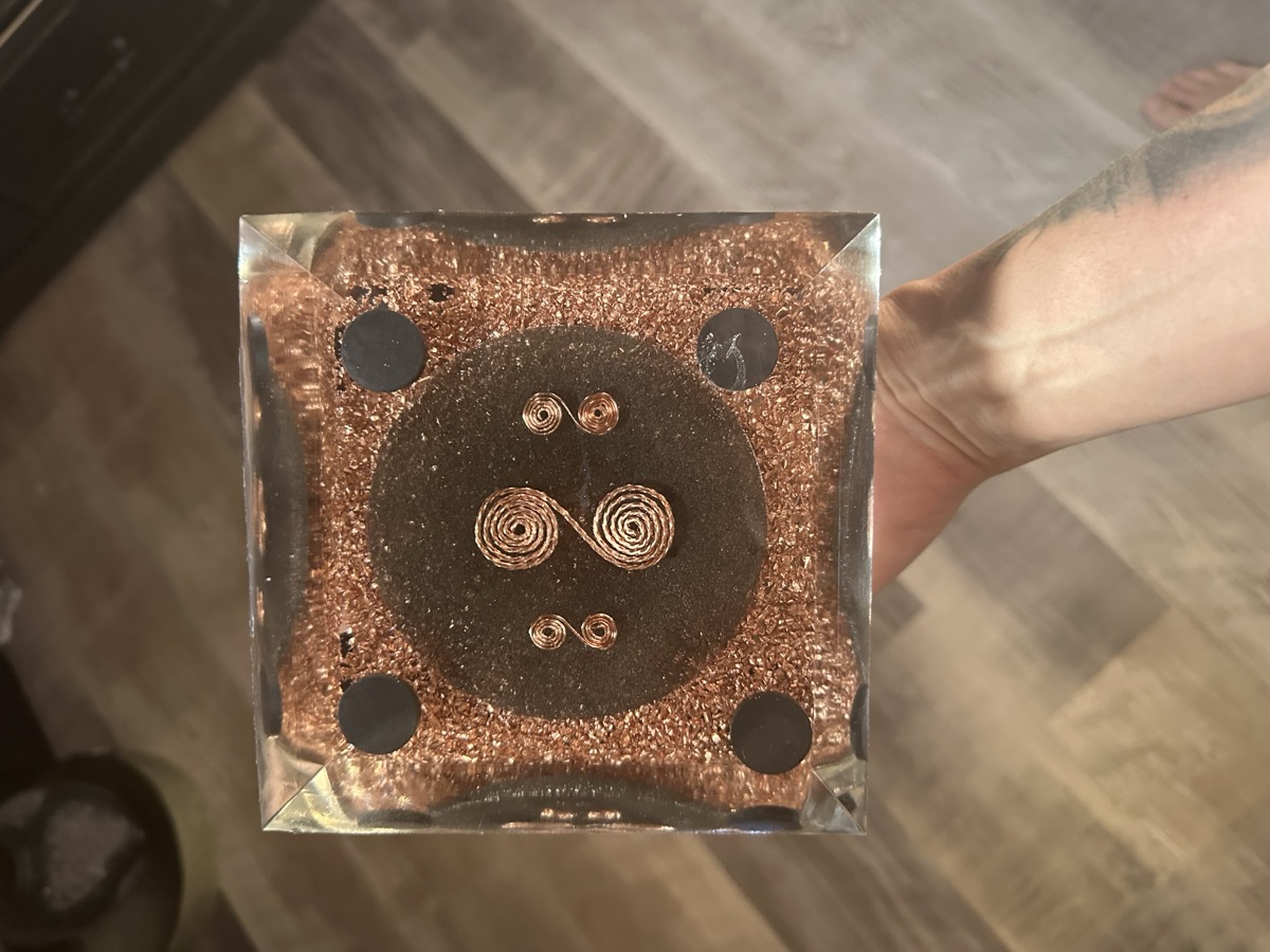 Handmade large orgonite pyramid with iron circle and four magnets visible through clear resin layers