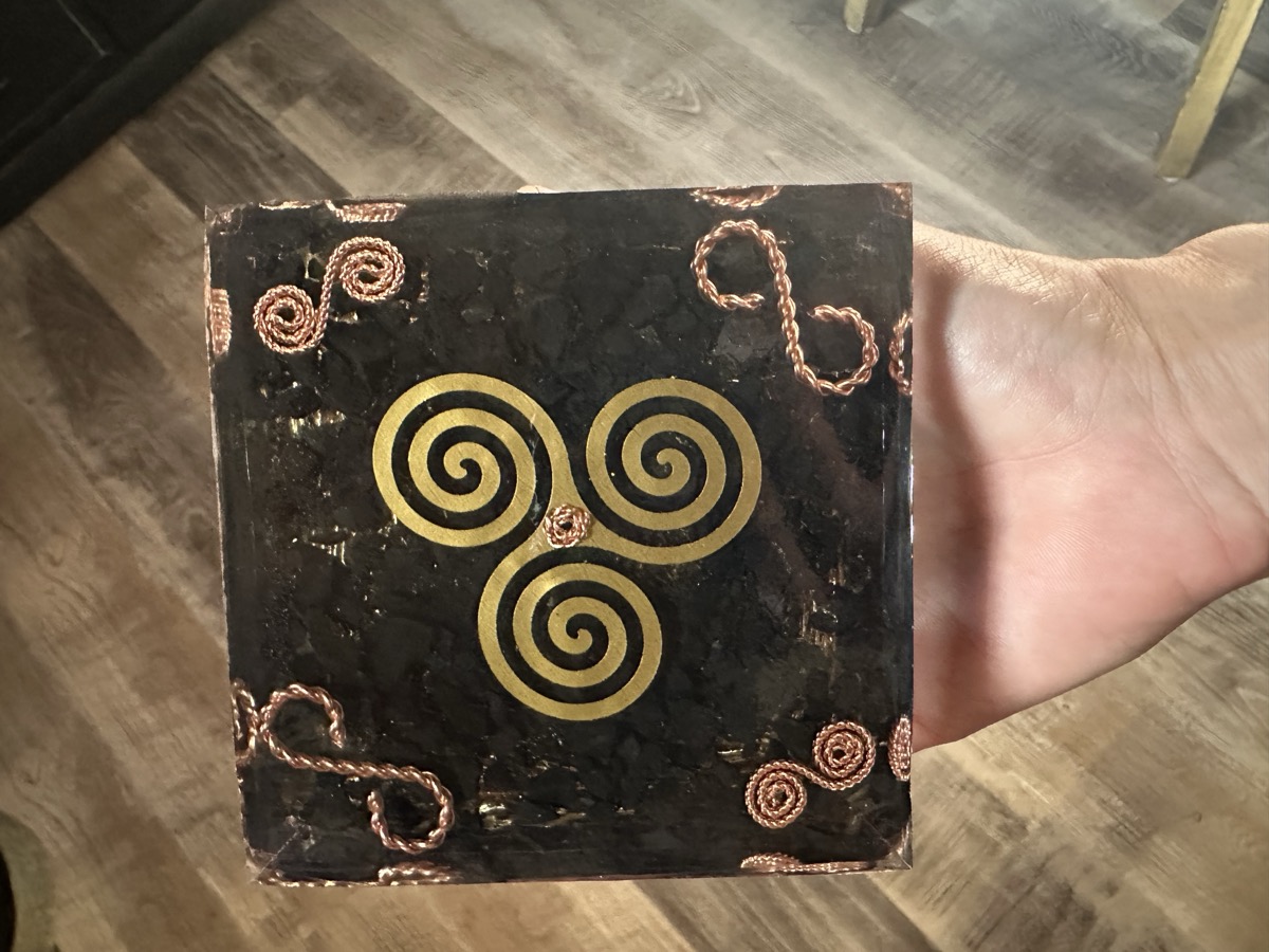 Handmade small orgonite pyramid with copper infinity symbol base and triskelion in clear resin