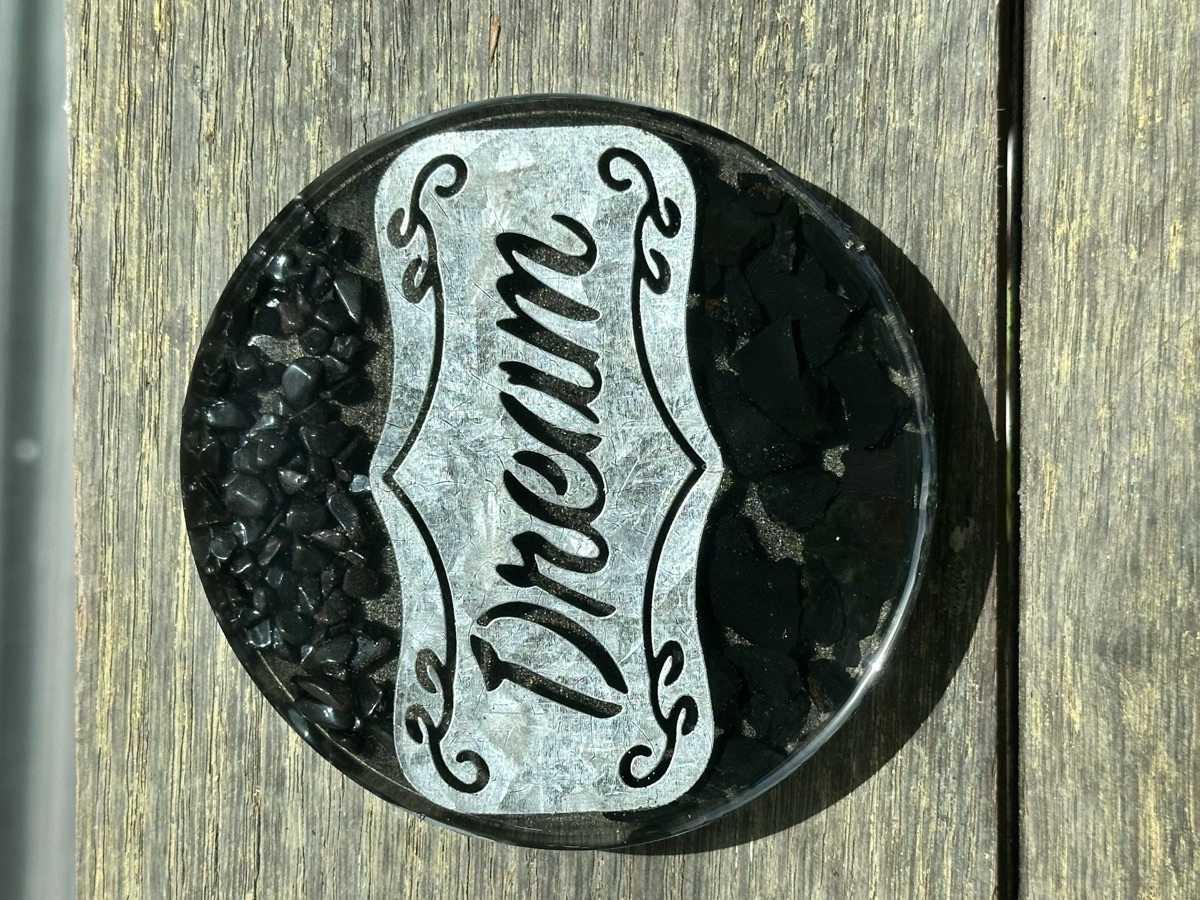 Iron filings, hematite, and shungite layered in dark resin with copper elements.