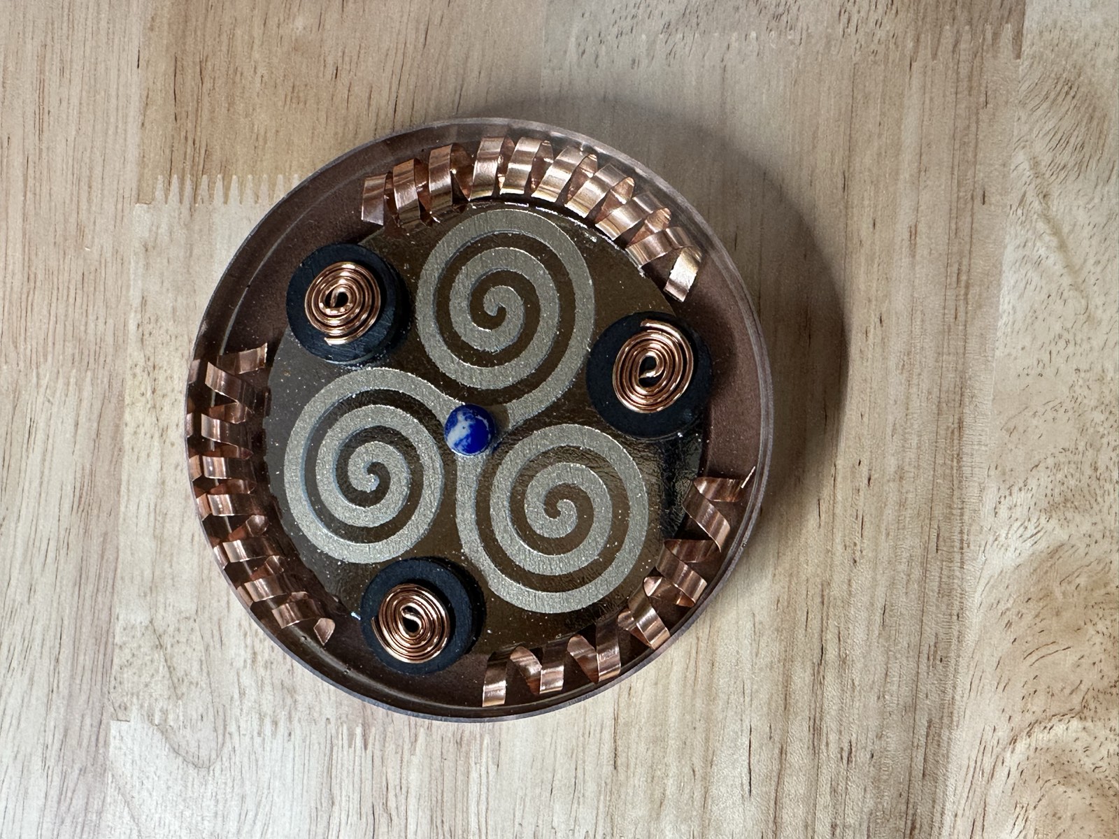 Silver triple spiral on mirrored black resin with ruffled copper ribbon edge and three copper-topped magnets.